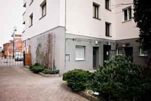 a white building on a brick sidewalk next to a building at Luxury apartment in the Old town Warsaw in Warsaw