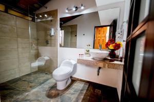 a bathroom with a toilet a sink and a mirror at La Campana Hotel Boutique in Medellín