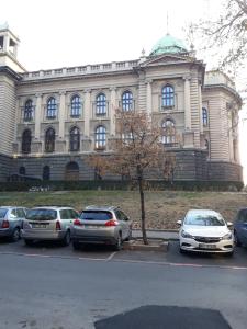 a building with cars parked in a parking lot at Apartment Paradise SunShine in Belgrade
