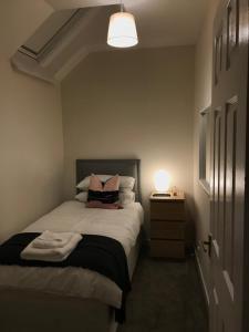 a bedroom with a bed with a lamp on it at 2 Lower Kessock Street in Inverness