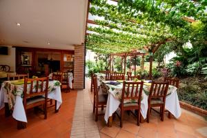 a dining area with tables and chairs and umbrellas at La Campana Hotel Boutique in Medellín