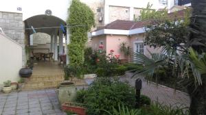 einen Innenhof eines Hauses mit Pflanzen und Bäumen in der Unterkunft Rooms & Apartments Boskovic in Budva