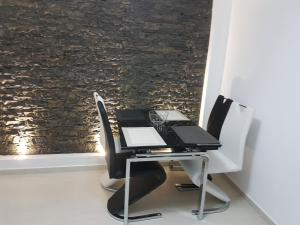 a desk with two chairs and a laptop on it at Amedeea Accomodation in Timişoara