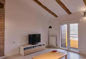 sala de estar con TV y mesa en BUENAVISTA AMBELES, en Teruel