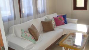 un sofá blanco con almohadas en la sala de estar en Sole Mio, en Milina