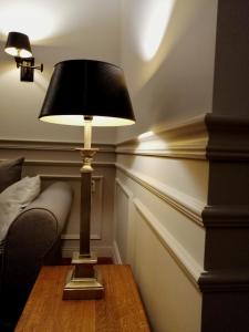 a lamp sitting on a table next to a bed at apartament in Koło