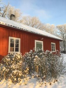 a red house with snow on top of it at Dränghuset in Broddetorp