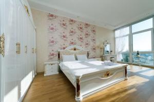 キーウにあるPanoramic luxury apartments with Jacuzzi Obolonskaya embankmentの花の壁のベッドルーム(白いベッド1台付)