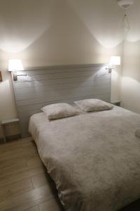 a bedroom with a large white bed with two pillows at EXCEPTIONNEL, maison de vacances dans parc, climatisation, parking, calme assuré in Marseille
