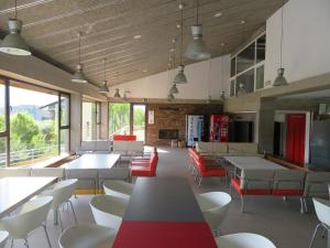 a dining room with tables and chairs and windows at Alberg la Bruna in Bellver de Cerdanya 