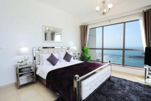 a bedroom with a large bed and a large window at Luxury Casa - Marvel Sea View Apartment JBR Beach 2BR in Dubai