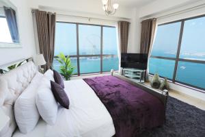 a bedroom with a large bed with a large window at Luxury Casa - Marvel Sea View Apartment JBR Beach 2BR in Dubai