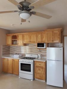 a kitchen with a white stove and a white refrigerator at Manderley Villas in Saint Philip