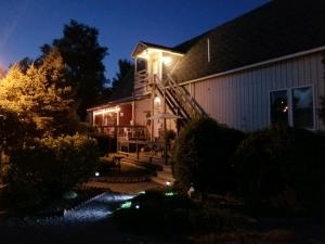 a house with lights on the side of it at night at Lake Ontario Motel & Inn in Newfane