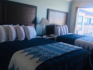a hotel room with two beds and a window at Dolphin Cove Motel in Pismo Beach