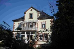 a large house with a balcony on top of it at l'âROMEantic in Rothau