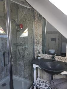 a bathroom with a black sink and a shower at l'âROMEantic in Rothau