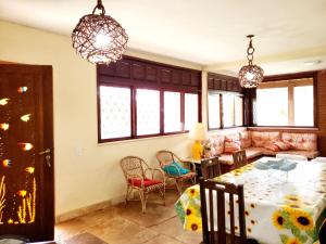 a dining room and living room with a table and chairs at Casa Sitio Região dos Lagos 1200m2 terreno- S Pedro DAldeia in São Pedro da Aldeia