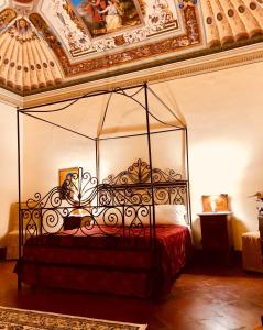 een slaapkamer met een bed met een metalen baldakijn bij B&B Il Gianduia in Lucignano