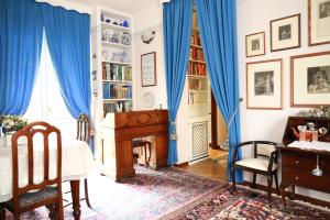 AlbavillaにあるGolden Memories Holiday Homeのリビングルーム(青いカーテン、ピアノ付)