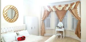 a bedroom with a bed and a window with a mirror at Gabriel Guesthouse in Rhyl