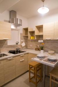 uma cozinha com armários de madeira, um lavatório e uma mesa em Limone em Capitana
