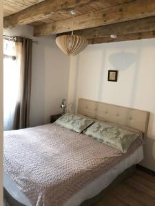 sypialnia z dużym łóżkiem i drewnianym sufitem w obiekcie Studio Fontaine d’amour w mieście Sarlat-la-Canéda