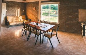 a dining room with a table and chairs and a couch at El Retiro - Casa de campo en Los Reartes in Los Reartes