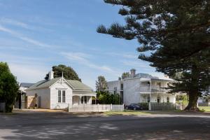 a white house with a tree in front of it at Drift House in Port Fairy