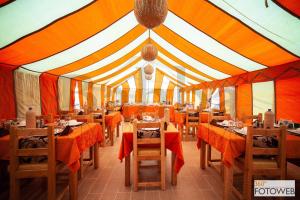 a dining room with tables and chairs in a tent at Sahara Happy Camp in Merzouga