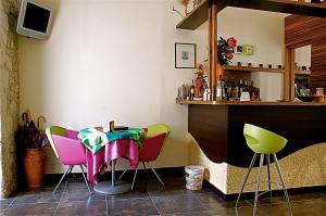 a bar with colorful chairs and a table at Le Cinque Luci in Modica