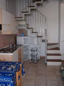 a kitchen with a spiral staircase in a room at Maremaremma Sporting Club Rio Grande in Principina a Mare