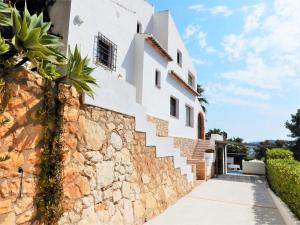 ein weißes Haus mit einer Steinmauer und einer Treppe in der Unterkunft Villa Tosalet Pomelo in Jávea