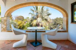 uma mesa e cadeiras num quarto com uma janela em Villa Tosalet Pomelo em Xàbia