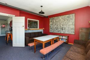 a living room with a table and a couch at The Rotten Apple Backpackers in Hastings