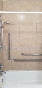 een douche in een badkamer met een tegelwand bij Royal Inn Motel Long Beach in Long Beach