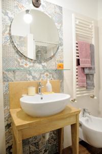 La salle de bains est pourvue d'un lavabo blanc et d'un miroir. dans l'établissement Santo Stefano, à Putignano
