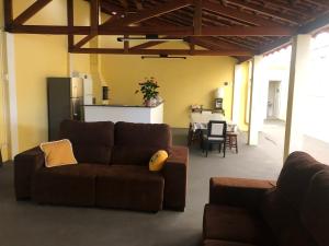 a living room with a couch and a kitchen at Suites Santa Amelia in Brotas