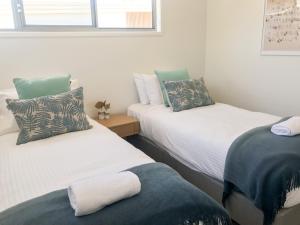 Un pat sau paturi într-o cameră la Fat Frog Beach Houses