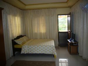 a bedroom with a bed and a window at Mary Chiang Baguio Transient House in Baguio