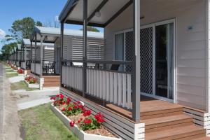 a row of modular homes with red flowers on a sidewalk at BIG4 Dandenong Tourist Park in Dandenong