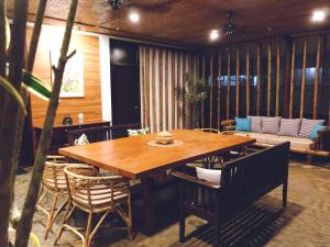 a dining room with a wooden table and chairs at The Cabins at LVF in Puerto Princesa City