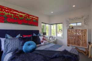 a bedroom with a bed with a blue pillow on it at Kohanga Rua Cottage by Amazing Accom in Queenstown