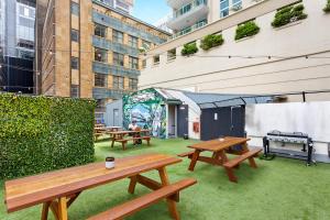 un patio con mesas de picnic y una parrilla en Sydney Backpackers en Sídney