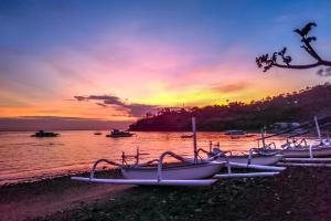 un groupe de bateaux garés sur la plage dans l'établissement Sunrise Cafe Bungalows, à Amed