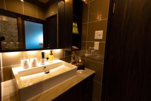 a bathroom with a white sink and a mirror at Hotel Gran Bali Resort in Kawasaki