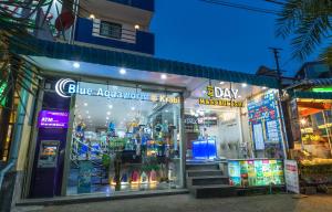 una tienda frente a una tienda con un cartel azul iluminado en iDeal Beds Hostel Ao Nang Beach, en Ao Nang Beach