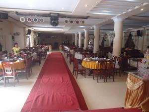 a dining hall with tables and chairs and a red carpet at Hue Railway Hotel in Hue