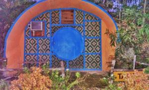 ein blaues und orangefarbenes Gebäude mit einem Fenster in der Unterkunft Kamp Aninipot in Siquijor