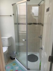 Cozy Rowhouse Next JHH في بالتيمور: دش زجاجي في حمام مع مرحاض
